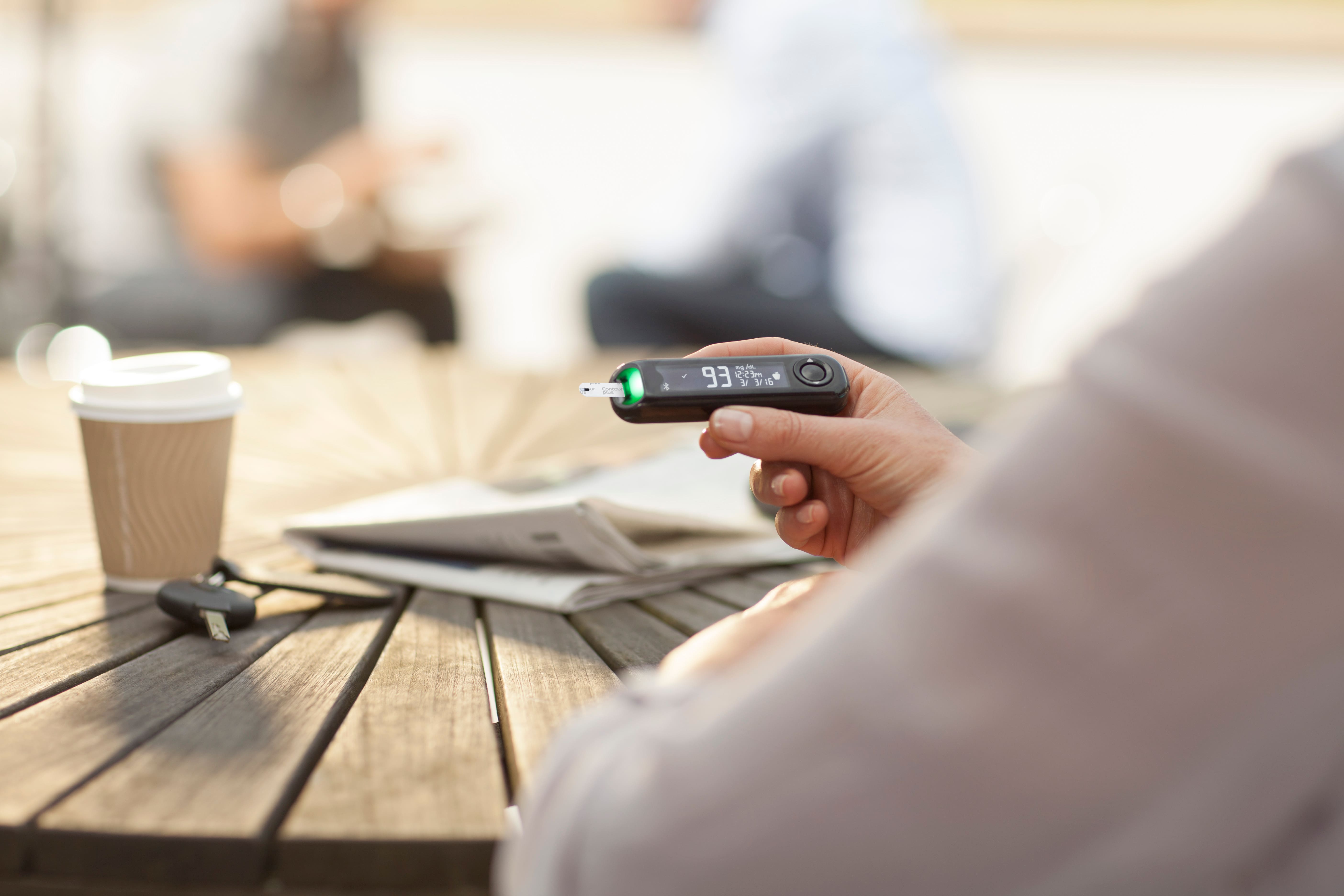 Person holding a blood glucose meter